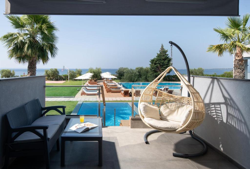 Terase pie Sea Coast Resort Halkidiki ar skatu uz baseinu un jūru.