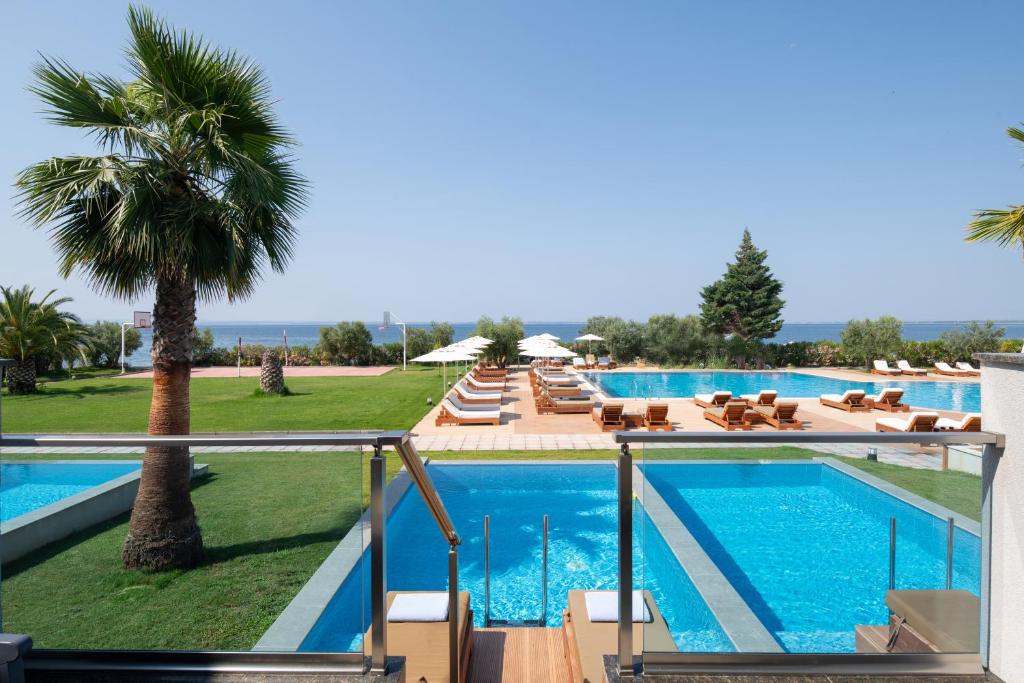 Sea Coast Resort Halkidiki baseins un plašs zāliena laukums piekrastē