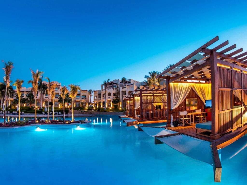 Grezens baseins ar kabīnēm pie Rixos Sharm El Sheikh saulrietā.