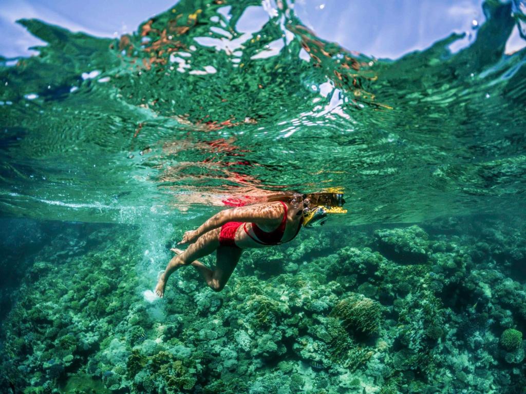 Viesnīcas Rixos Sharm El Sheikh viesis, kas snorkelē piekrastē.