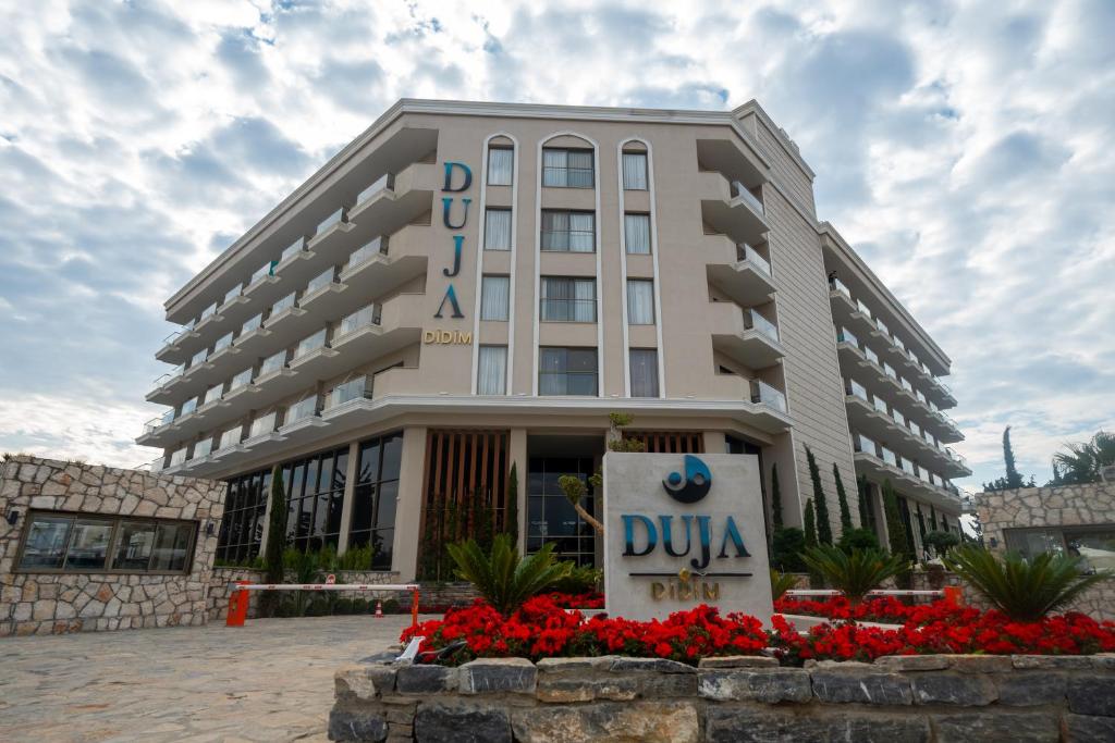 Viesnīca Duja Didim ar ziedu apstādījumiem pie ieejas