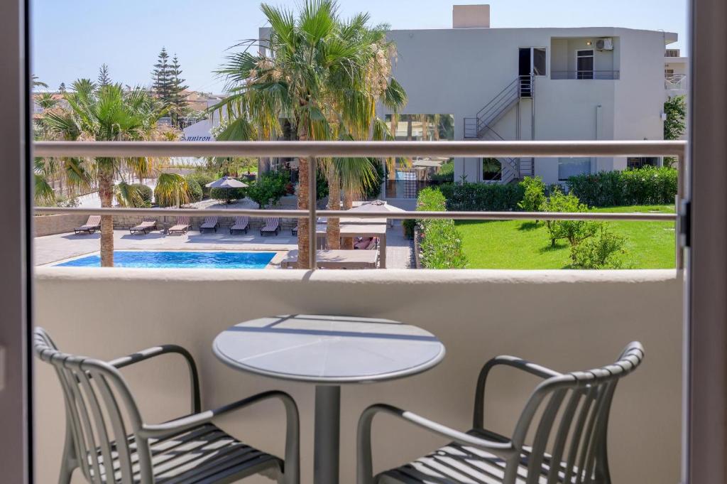Zeus Hotels Ydoria Resort numura balkons ar skatu uz baseinu un palmu kokiem.