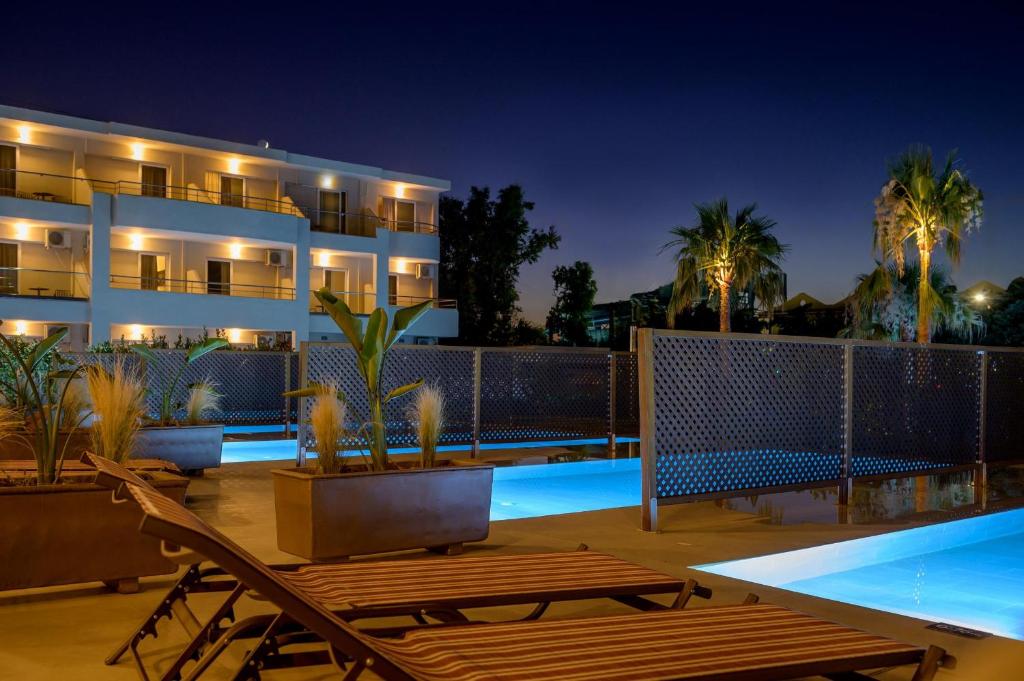 Zeus Hotels Ydoria Resort baseins piekrastē ar palmām naktī