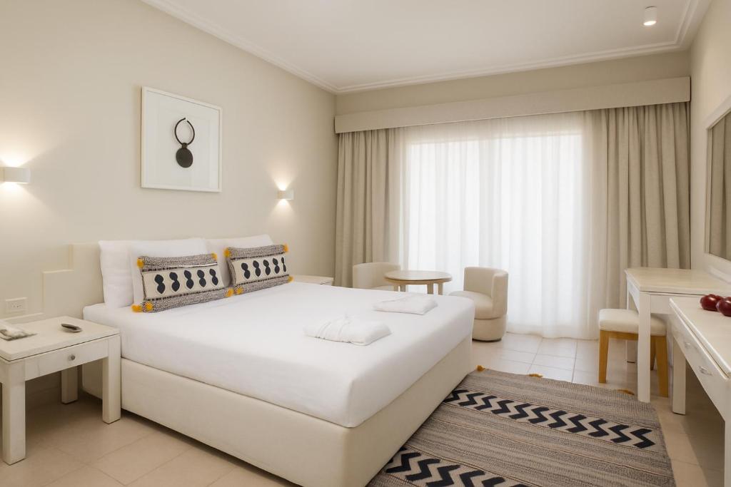 Mūsdienīgs numurs viesnīcā Sindbad Club ar ērtu gultu un dabiskiem apgaismojumiem.