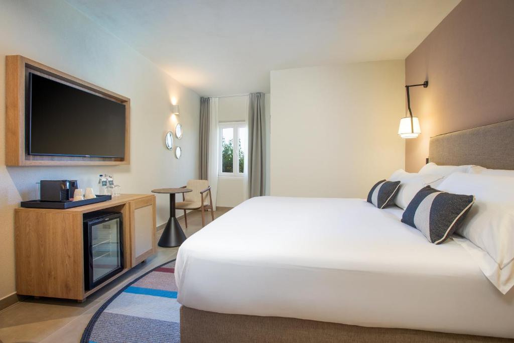 Moderns numurs Mangia's Sardinia Resort ar ērtu gultu.