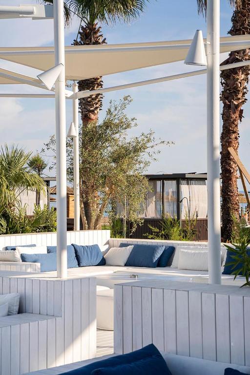 Viegla atpūtas zona pie Voyage Belek Golf & Spa ar baltām mēbelēm un palmām.