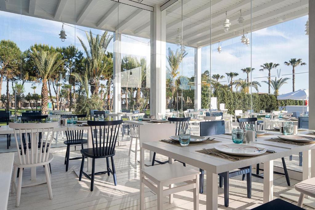 Eleganta ēdamzāle ar skatu uz palmu dārzu viesnīcā Voyage Belek Golf & Spa.