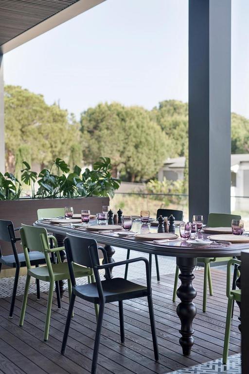 Pusdienu galds ārpusē pie Voyage Belek Golf & Spa ar zaļām un melnām krēslām.
