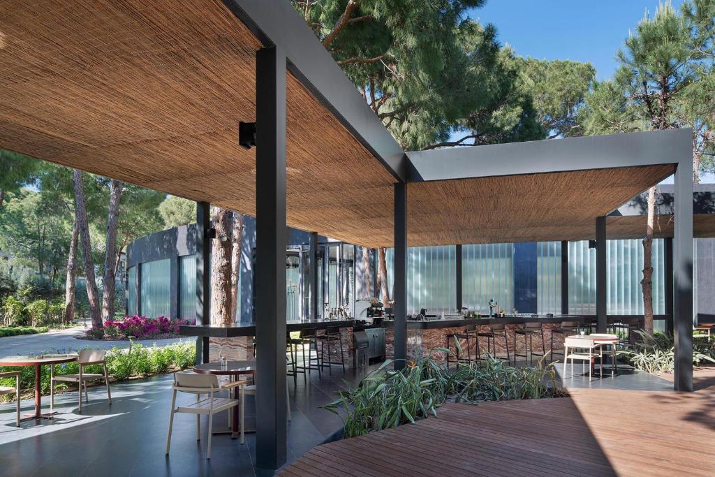 Āra restorāns pie Voyage Belek Golf & Spa ar ērtām mēbelēm un dabas skatu.