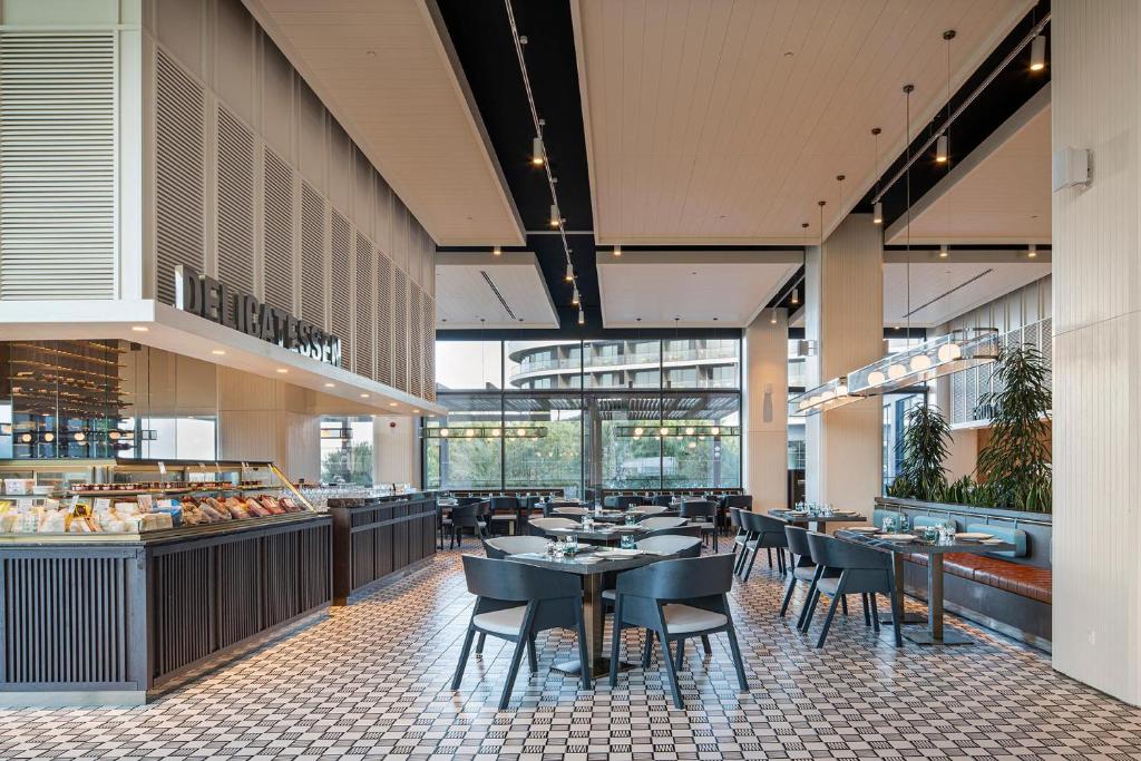 Mūsdienīgs restorāns ar elegantiem galdiem Voyage Belek Golf & Spa.