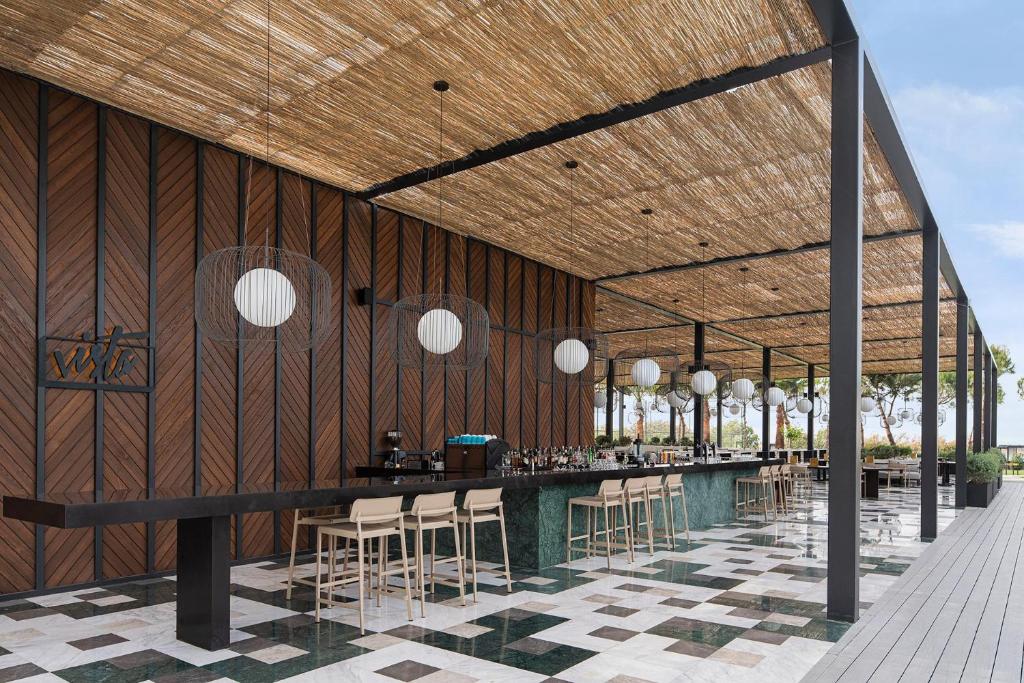 Vita bārs pie Voyage Belek Golf & Spa ar modernu interjeru un stilīgu apgaismojumu.