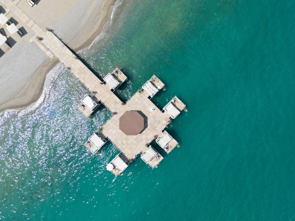 Skats uz piestātni pie Sherwood Exclusive Kemer, piekrastē ar kristāldzidru ūdeni.