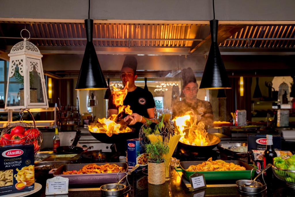 Pavāri gatavo gardus ēdienus viesnīcā Sherwood Exclusive Kemer, radošā atmosfērā.