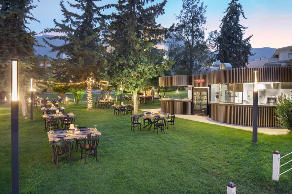 Mirage Park Resort dārza restorāns ar apgaismojumu un galdiem