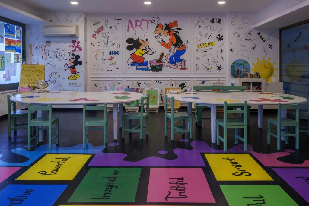 Radošā istaba bērniem viesnīcā Mirage Park Resort ar krāsainām sienām un galdiem.