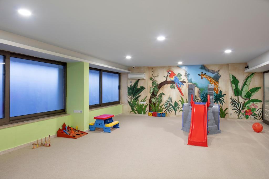 Bērnu rotaļu zona ar slidkalniņu un krāsainām sienu gleznām Mirage Park Resort