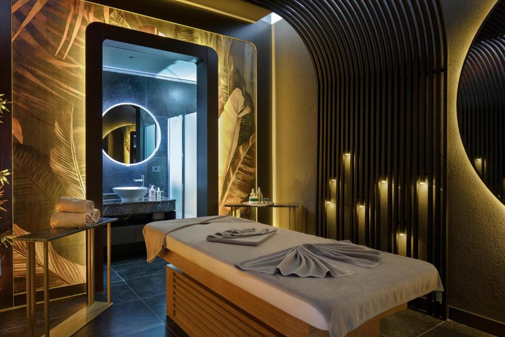 Spa telpa viesnīcā Mirage Park Resort ar masāžas galdu un elegantu interjeru.