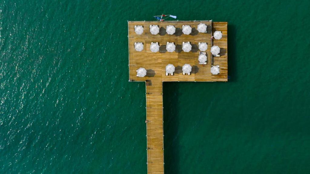 Koka mola skats pie Sherwood Exclusive Lara ar saulessargiem piekrastē.