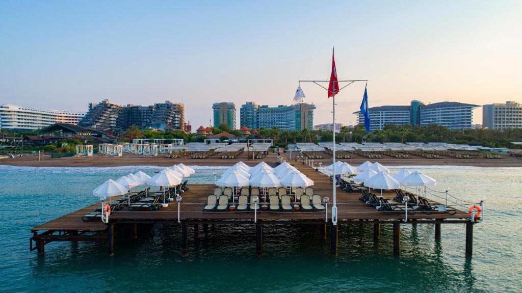 Mola piekrastē pie Sherwood Exclusive Lara ar saulessargiem un sauļošanās krēsliem.