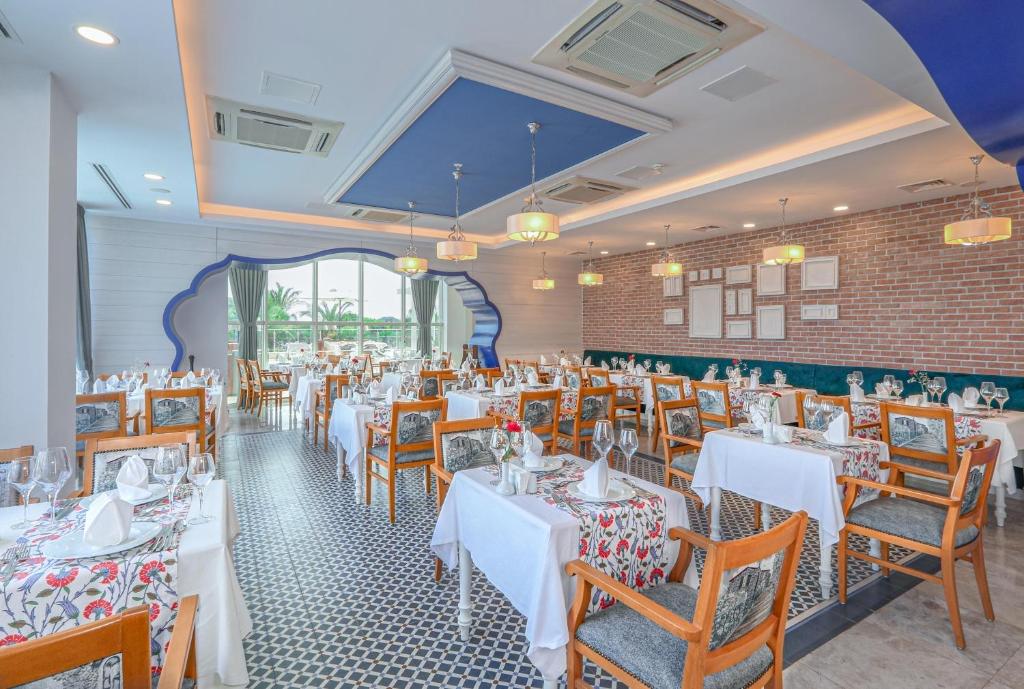 Eleganta restorāna iekārtojums viesnīcā Sherwood Exclusive Lara ar skatu uz dārzu.