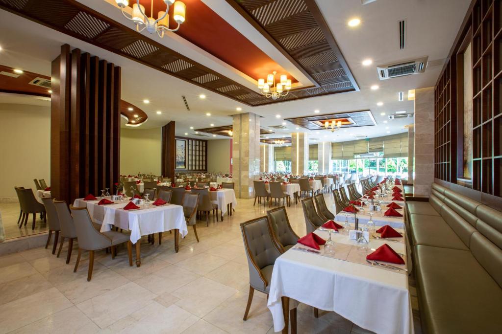 Restorāns viesnīcā Sherwood Exclusive Lara ar elegantām galdiem un krēsliem