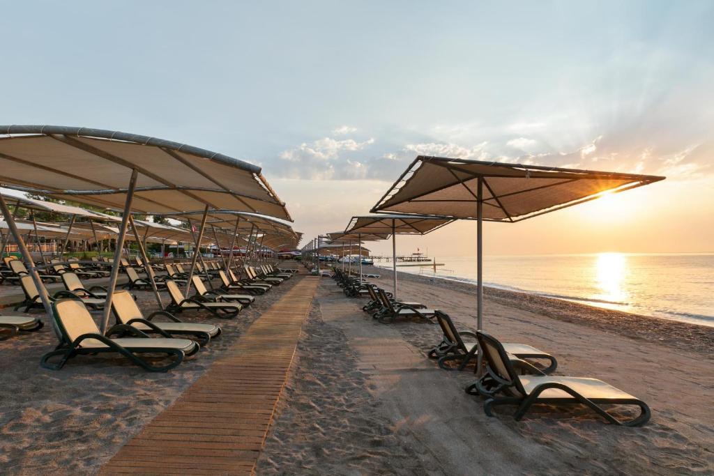 Sauļošanās krēsli pie pludmales saulrietā, Greenwood Kemer Resort