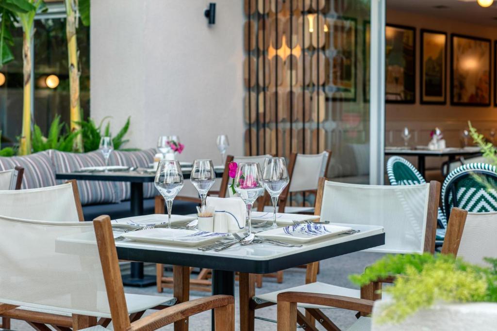 Eleganti izkārtots galds restorānā Greenwood Kemer Resort ar glāzēm un ziediem.