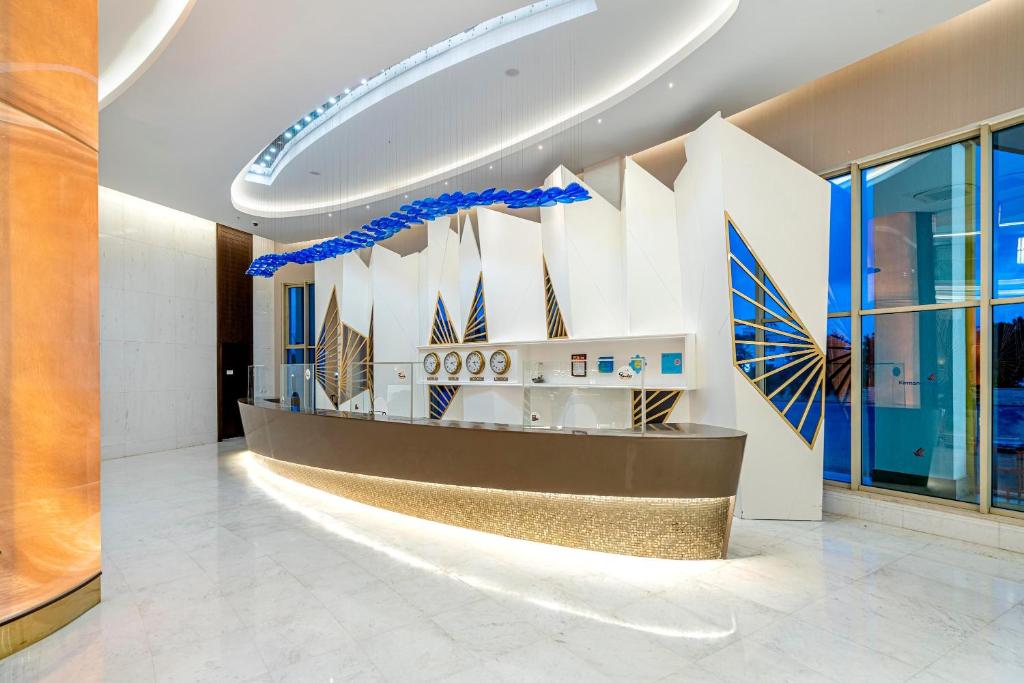 Recepcija Kirman Sidemarin Beach & Spa ar modernu dizainu un elegantu apgaismojumu.
