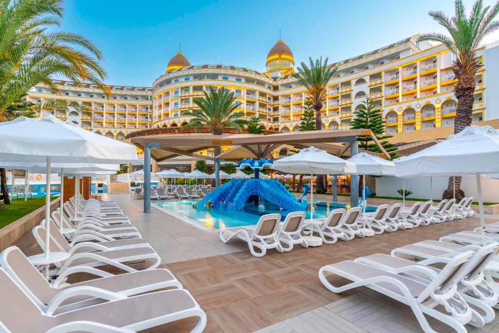 Baseins ar zilo slaidu un sauļošanās krēsliem pie Kirman Sidemarin Beach & Spa