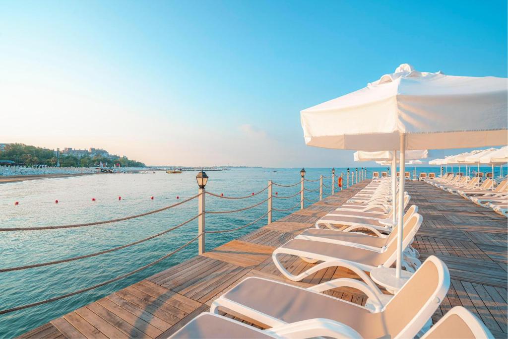 Viesnīcas Kirman Sidemarin Beach & Spa pludmales terase ar saulessargiem piekrastē.
