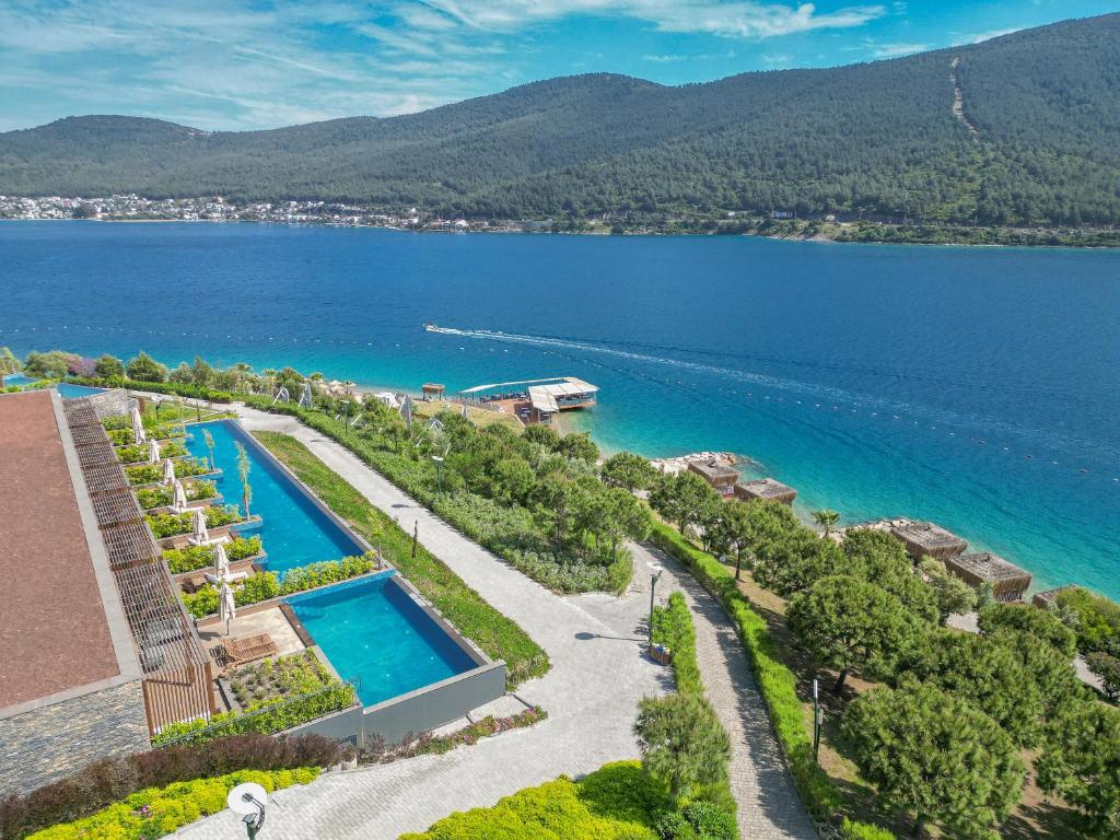 Skats uz La Blanche Island Bodrum piekrasti ar baseiniem un zaļām zonām.