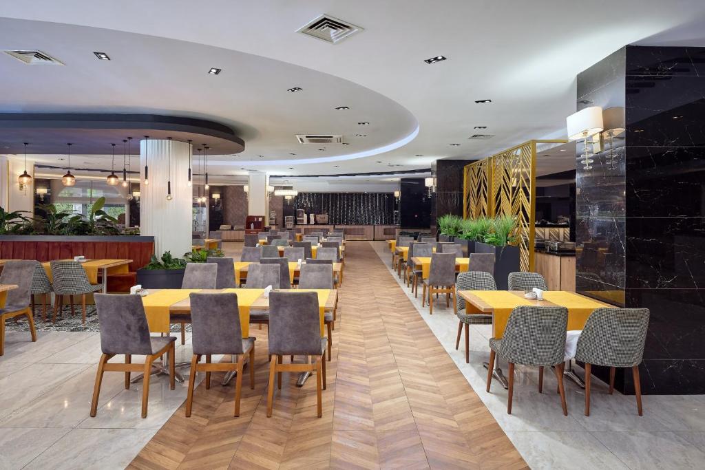 Mūsdienīgs restorāns Annabella Diamond Hotel ar elegantiem galdiem un krēsliem.