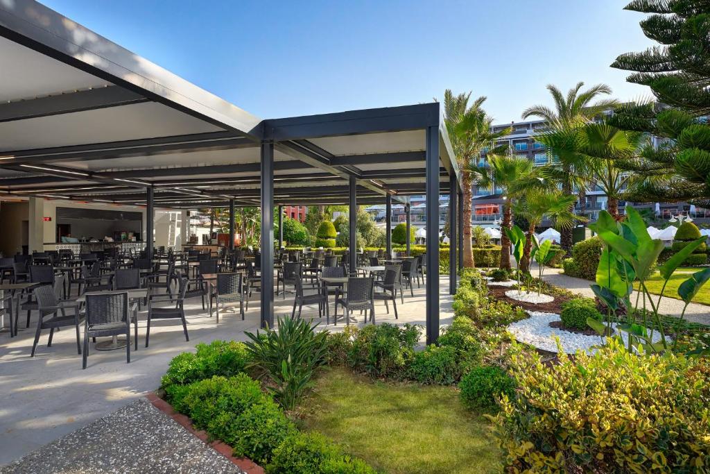 Āra restorāns pie Annabella Diamond Hotel ar dārza ainavu.