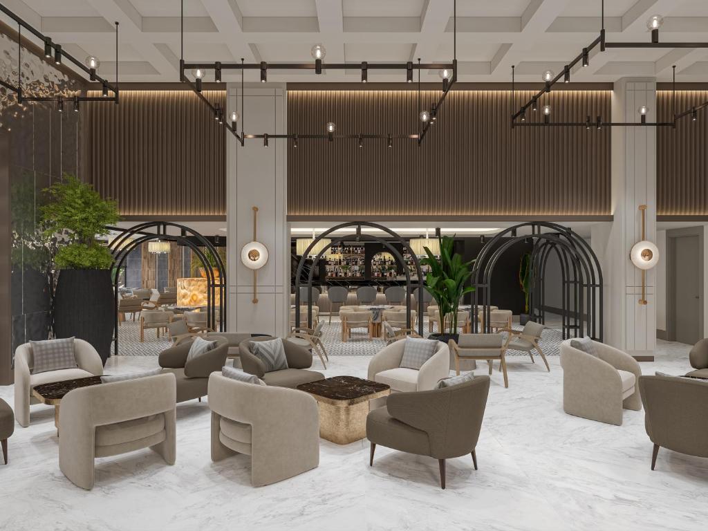 Mūsdienīgs viesnīcas Annabella Diamond Hotel vestibils ar elegantiem krēsliem un bāru.