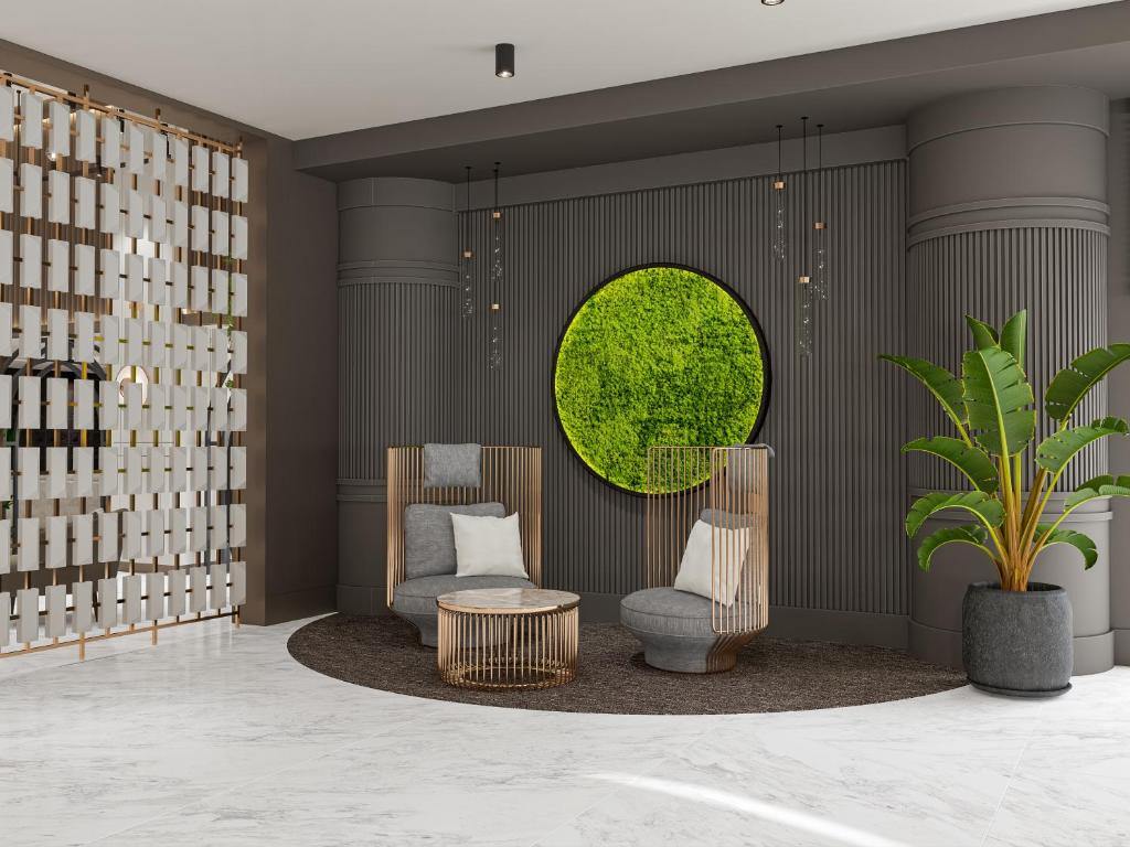 Mūsdienīgs viesnīcas Annabella Diamond Hotel interjers ar ērtām krēslām un zaļo akcentu.