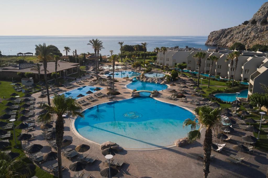 Atlantica Aegean Blue viesnīcas peldbaseins piekrastē ar palmām