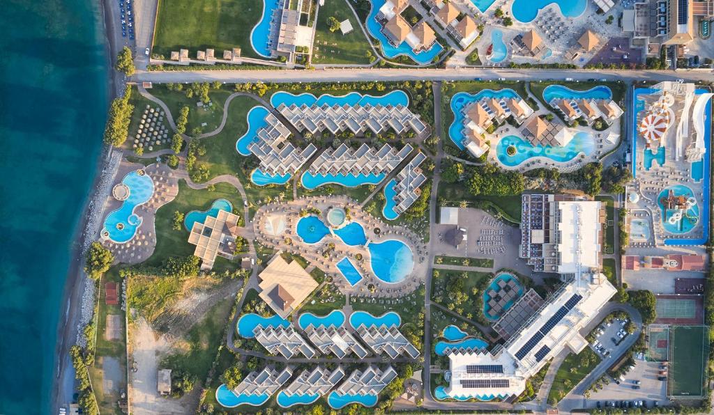 Atlantica Aegean Blue viesnīca ar plašiem baseiniem un zaļiem laukumiem piekrastē.