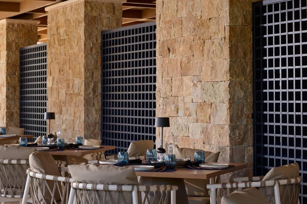 Elegantā restorāna interjers Atlantica Aegean Blue, akmens sienas un galdi