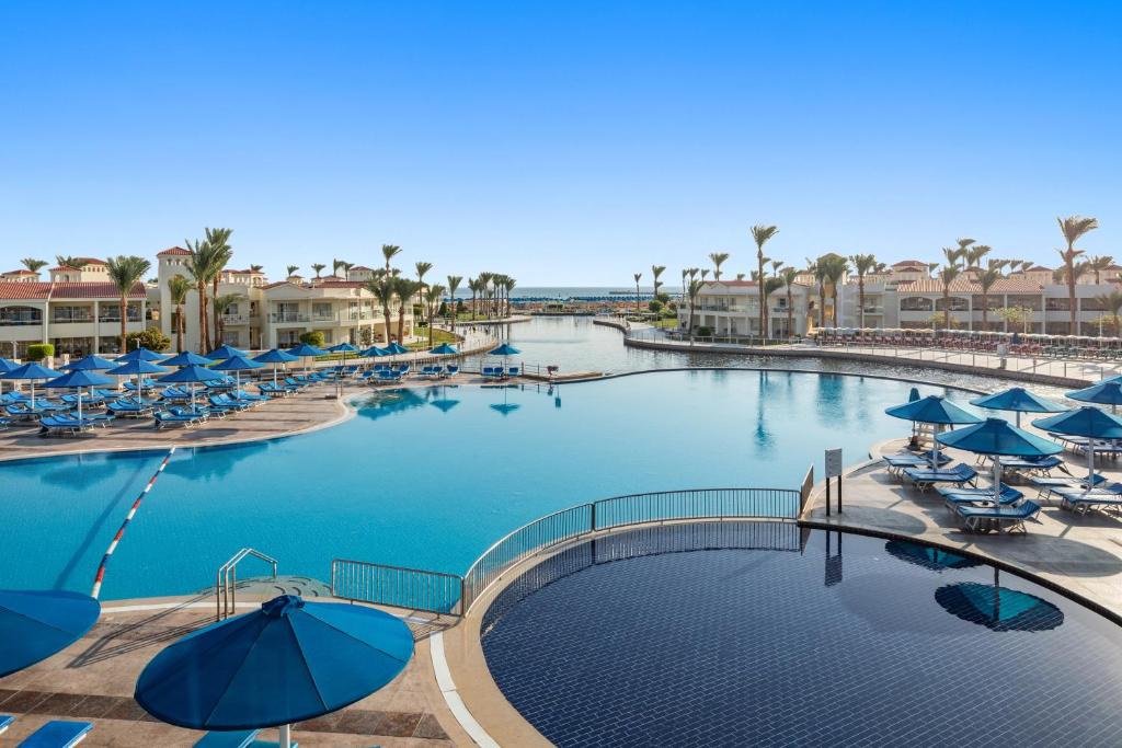 Baseins pie Pickalbatros Dana Beach Resort ar saules krēsliem.