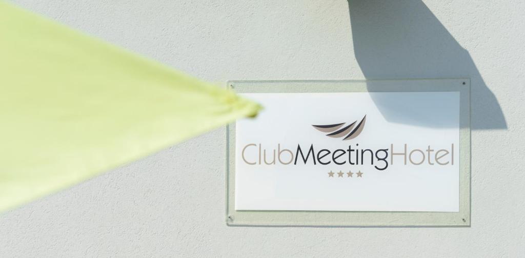 Kluba sapulču viesnīcas zīme ar četrām zvaigznēm, kas piestiprināta pie sienas.