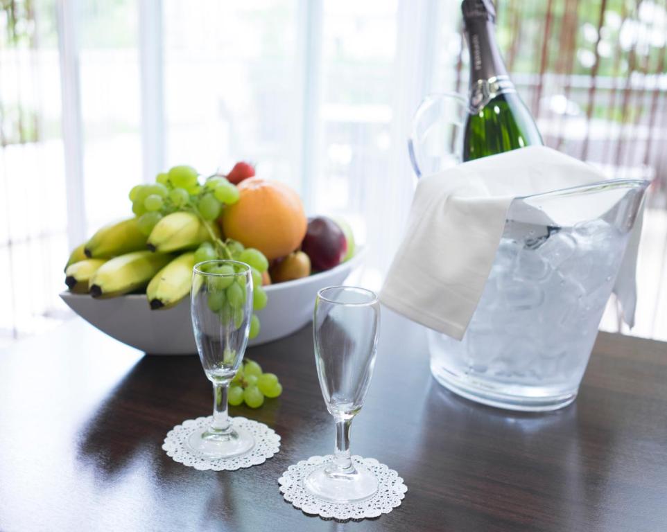 Galda uzkodu kompozīcija ar augļu trauku, ledus spaini un divām šampanieša glāzēm, kas novietotas uz eleganta galda.