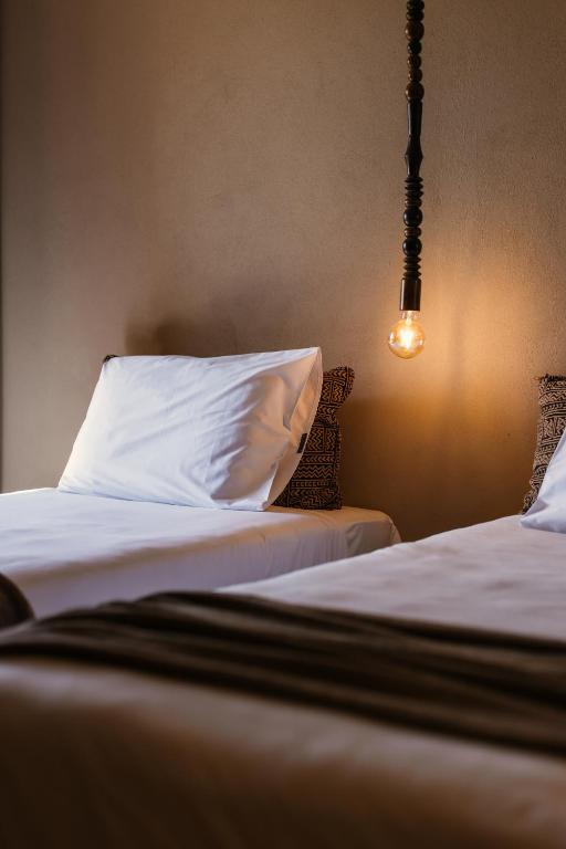 Moderns numurs ar divām gultām un stilīgu apgaismojumu Cook's Club El Gouna.