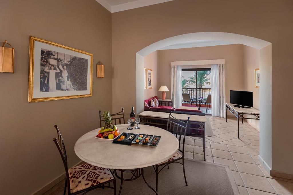 Viesnīcas Jaz Makadi Saraya Resort numurs ar ēdamgaldu un balkonu