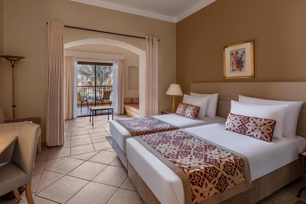 Numurs ar divām gultām un terasi pie Jaz Makadi Saraya Resort.