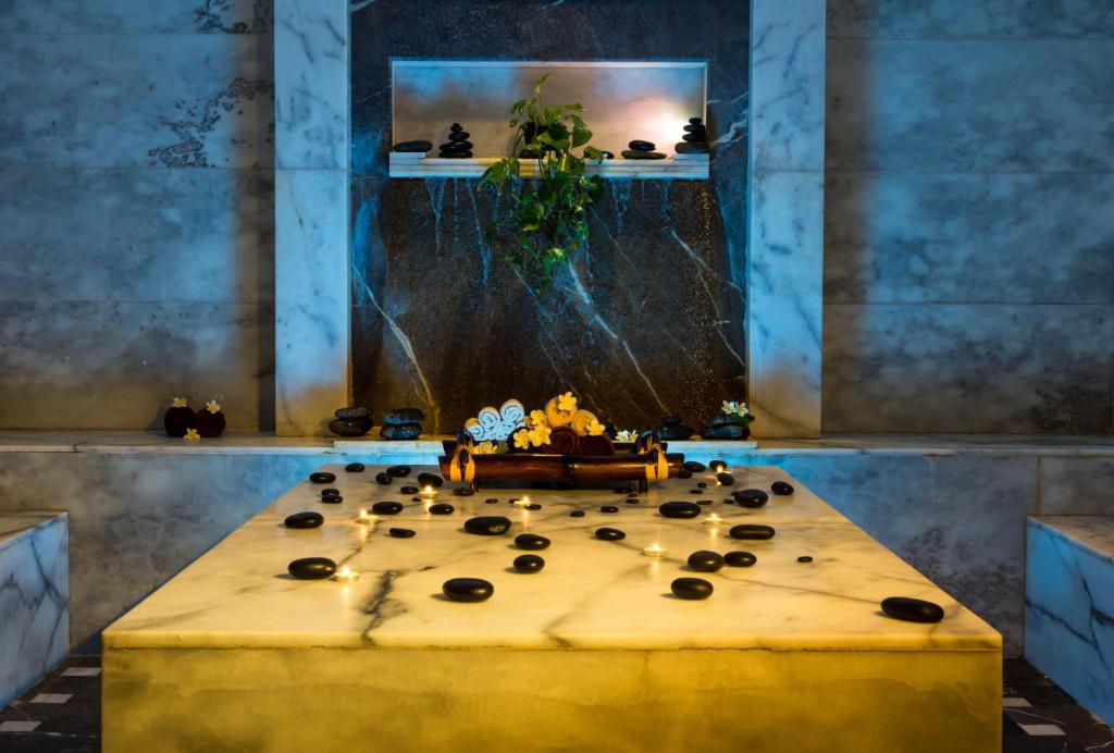 Relaksējošs spa galds ar akmeņiem un ziediem Jaz Makadi Saraya Resort.