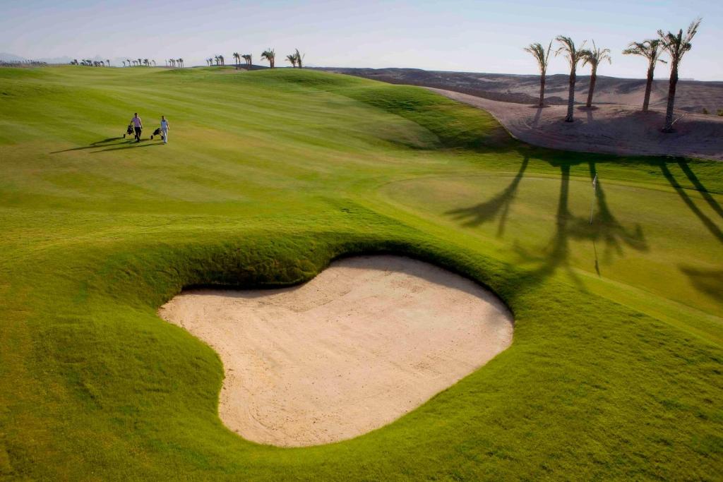 Golf spēlētāji dodas pa zaļo laukumu Jaz Makadi Saraya Resort