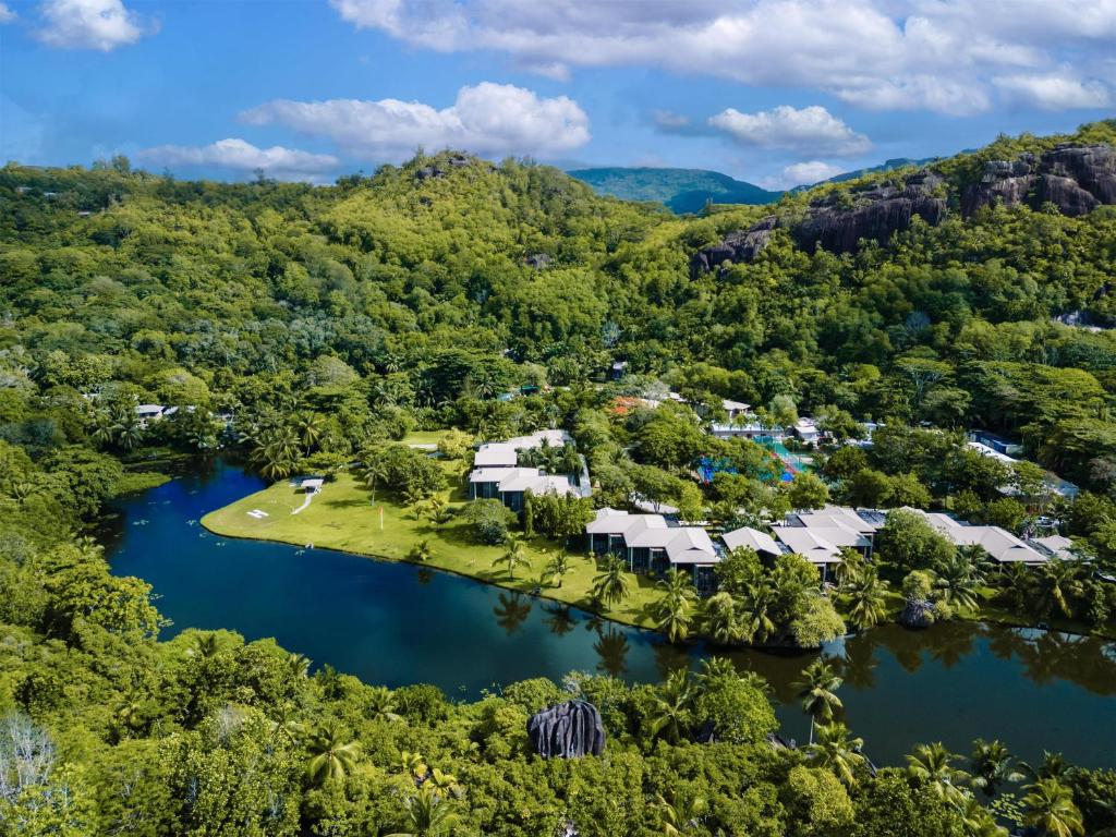 Kempinski Seychelles Resort panorāmas skats ar lagūnu un tropu kalniem fonā