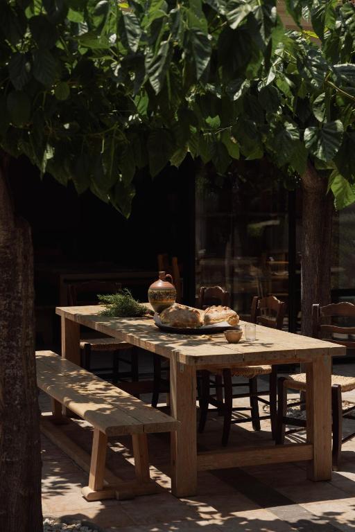 Pusdienu galds pie Phāea Cretan Malia, rotāts ar maizi un keramikas traukiem.