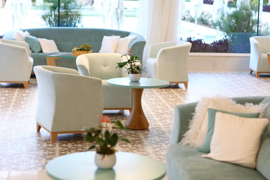 Mūsdienīgs un elegants viesnīcas interjers ar gaišām krāsām, ērtiem dīvāniem un galdiem, kas rada patīkamu atmosfēru. Ideāli piemērots relaksācijai vai sarunām.