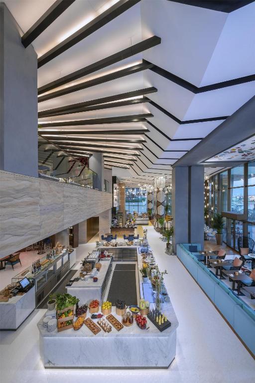 Restorāns Andaz Dubai The Palm ar modernu interjeru un izsmalcinātu bufeti.